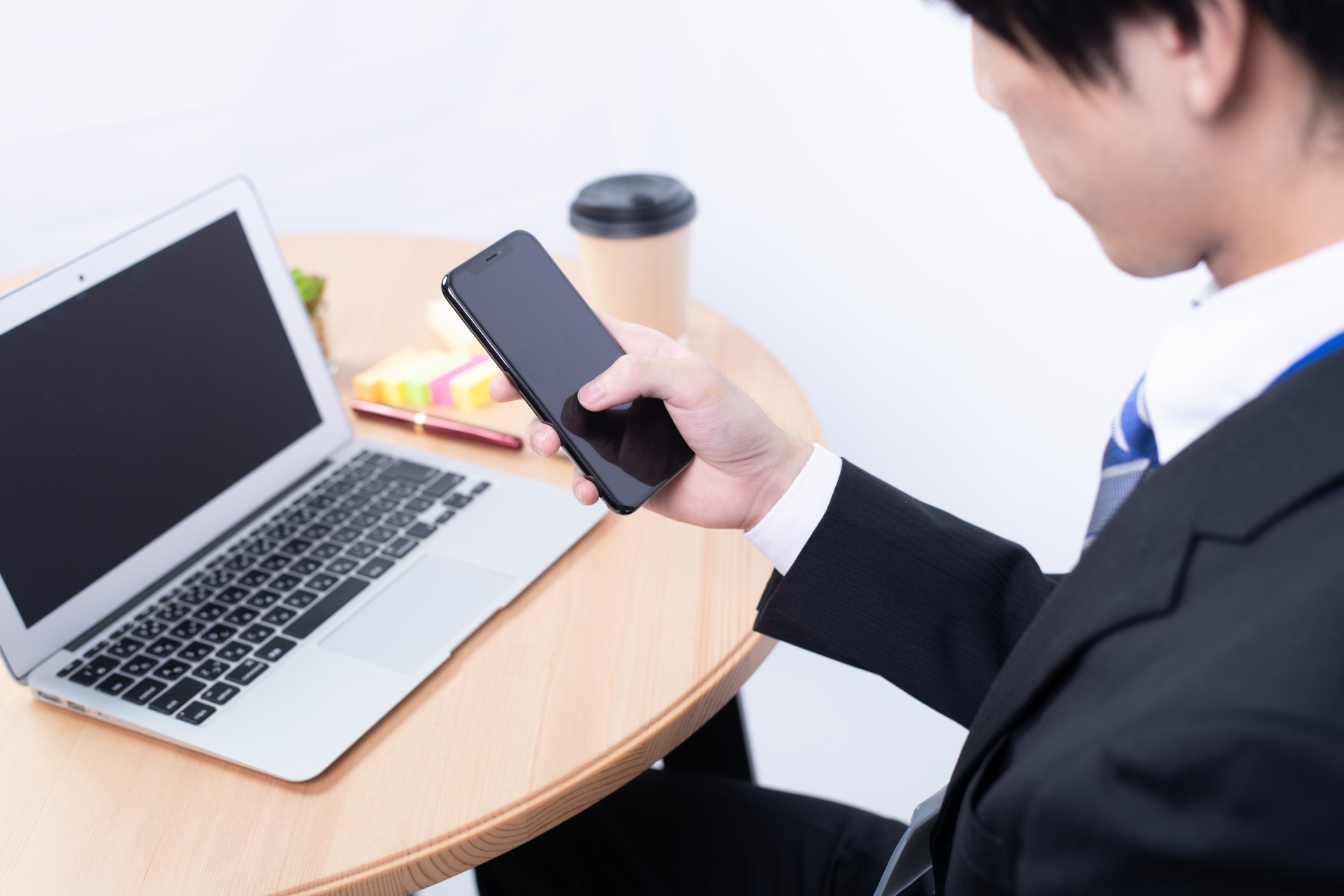 「PCを開いて作業しているサラリーマン」「スキマ時間にスマホを操作している人